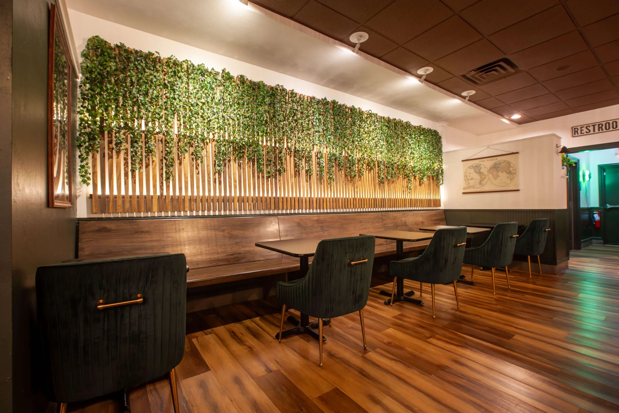 Red leather booths beneath a living wall