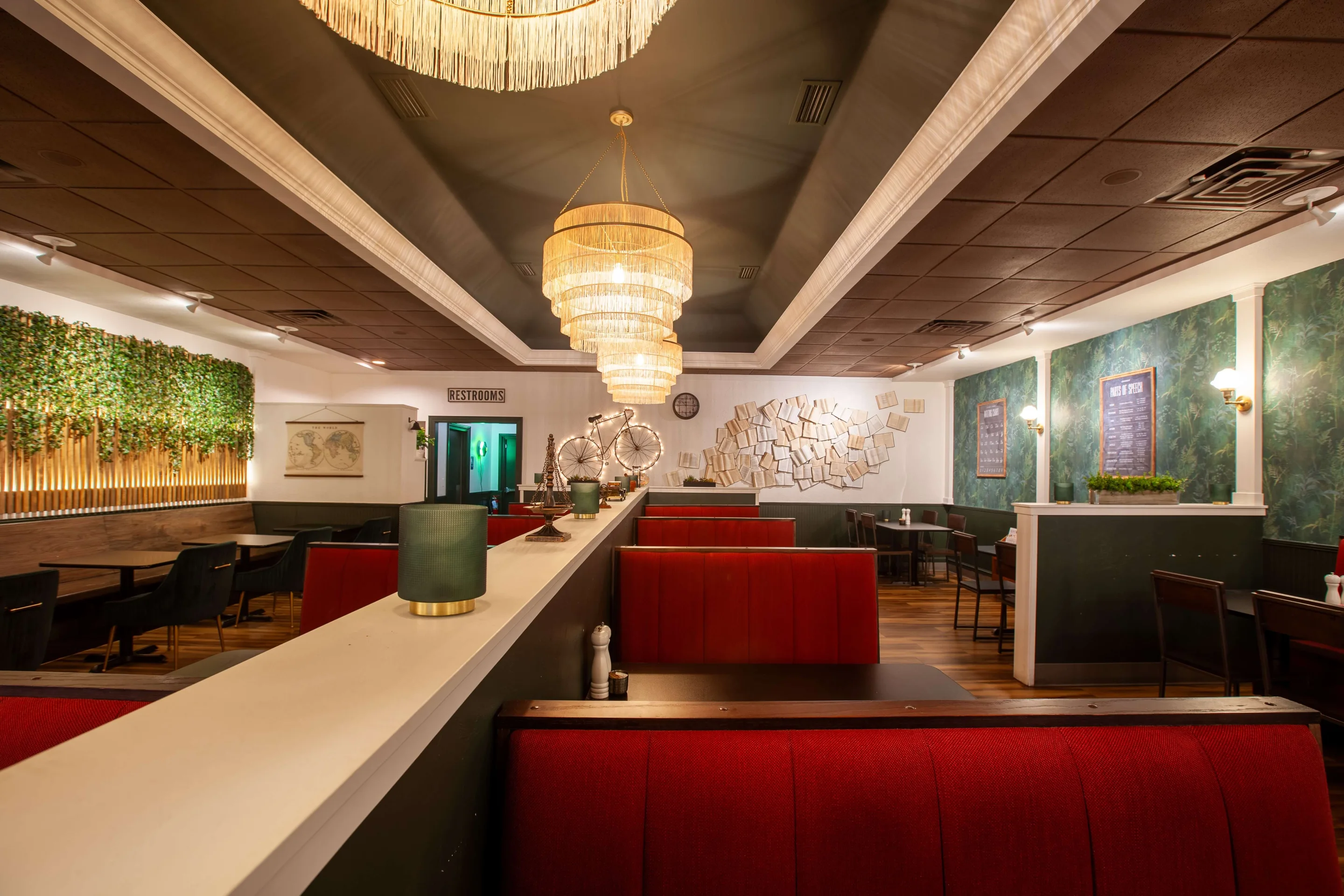 Scuola Pizza dining room with red leather booths, a living green wall and woven chandeliers